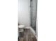 Bathroom with toilet, tiled floor, and a walk-in shower with glass enclosure at 5053 N Beach Rd # 9, Englewood, FL 34223