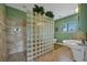 Spa-like bathroom with walk-in shower, soaking tub, and glass block wall at 429 Flamingo Dr, Apollo Beach, FL 33572