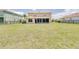 Expansive, lush backyard enclosed by a wrought iron fence and rear view of the rear lanai at 228 Star Shell Dr, Apollo Beach, FL 33572