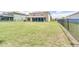 Expansive, lush backyard enclosed by a wrought iron fence and rear view of the rear lanai at 228 Star Shell Dr, Apollo Beach, FL 33572