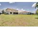 Expansive, lush backyard enclosed by a wrought iron fence and rear view of the rear lanai at 228 Star Shell Dr, Apollo Beach, FL 33572