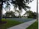 Outdoor basketball court surrounded by mature trees and lush green grass at 228 Star Shell Dr, Apollo Beach, FL 33572