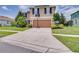 Two story home with a manicured lawn, mature trees, large driveway, and a two car garage at 228 Star Shell Dr, Apollo Beach, FL 33572
