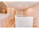 This hallway includes wood floors, neutral walls, and recessed lighting at 228 Star Shell Dr, Apollo Beach, FL 33572