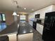 The kitchen boasts white cabinets, modern backsplash, island, and black appliances at 228 Star Shell Dr, Apollo Beach, FL 33572