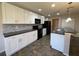 The kitchen features white cabinets, modern backsplash, island, and black appliances at 228 Star Shell Dr, Apollo Beach, FL 33572