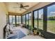 Relax in this sunroom featuring an overhead fan, tile floors, and wall-to-wall windows offering a backyard view at 228 Star Shell Dr, Apollo Beach, FL 33572