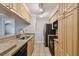 Kitchen with light wood cabinets, granite countertops, and black appliances at 5306 Santa Rosa Ct # 342, Tampa, FL 33609