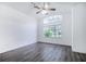 Bright bedroom with wood-look floors, ceiling fan, and large window at 6120 Cezanne Ave, Lutz, FL 33558