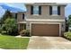 Two-story house with brown garage door and landscaping at 228 Star Shell Dr, Apollo Beach, FL 33572