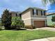 Two-story house with brown garage door and landscaping at 228 Star Shell Dr, Apollo Beach, FL 33572