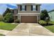Two-story house with brown garage door and landscaping at 228 Star Shell Dr, Apollo Beach, FL 33572