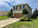 Two-story house with brown garage door and landscaping at 228 Star Shell Dr, Apollo Beach, FL 33572