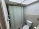 Clean bathroom with a toilet, shower, and a patterned curtain at 6297 Harcross Ct, Spring Hill, FL 34606