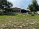 Large backyard with an open area, a partially visible fence and a rocking chair at 6297 Harcross Ct, Spring Hill, FL 34606