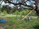 Backyard with a large tree, chain link fence, and garden at 6297 Harcross Ct, Spring Hill, FL 34606