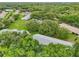 Aerial view of a property showcasing lush landscaping, mature trees, and well-maintained neighborhood streets at 1606 Laughton Pl, Sun City Center, FL 33573