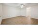 Bedroom with wood-look floors, ceiling fan, and views of the bathroom and hallway at 1606 Laughton Pl, Sun City Center, FL 33573