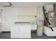 Bright laundry room features a full-size washer and dryer, utility sink, and shelving for organized storage at 1606 Laughton Pl, Sun City Center, FL 33573