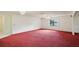 Spacious living area with red carpet and natural light at 1606 Laughton Pl, Sun City Center, FL 33573