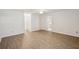 Open living room with wood-look floors, ceiling fan, and view of kitchen and hallway at 1606 Laughton Pl, Sun City Center, FL 33573