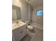 Updated bathroom with a white vanity, bathtub, and grey tile flooring at 710 E Alabama St, Plant City, FL 33563