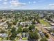 An aerial of a leafy neighborhood, showcasing a modern home and the city skyline on the horizon at 2909 W Spruce St, Tampa, FL 33607