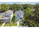 An elevated view of a two-story modern home situated among lush green trees and neighboring houses at 2909 W Spruce St, Tampa, FL 33607