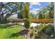 Lush backyard featuring a new tree, mulched beds, green grass and a wooden fence at 2909 W Spruce St, Tampa, FL 33607