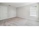 Comfortable bedroom showcasing neutral carpet, a bright window, and white trim for a clean look at 2909 W Spruce St, Tampa, FL 33607