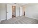 An open view of the bedroom with neutral walls, a light gray carpet and doors to other areas at 2909 W Spruce St, Tampa, FL 33607