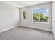 Bright bedroom with carpet, light colored walls and two windows looking out onto a lush, green landscape at 2909 W Spruce St, Tampa, FL 33607