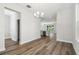 Bright dining room featuring hardwood floors, modern chandelier, and open layout to kitchen and living area at 2909 W Spruce St, Tampa, FL 33607