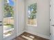 Cozy entryway featuring wood floors, glass door to backyard, and a window with lush greenery views at 2909 W Spruce St, Tampa, FL 33607