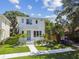 Modern two-story home with a blue door, manicured lawn, and landscaping with white rocks at 2909 W Spruce St, Tampa, FL 33607