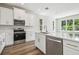 Bright kitchen features stainless steel appliances and white cabinetry at 2909 W Spruce St, Tampa, FL 33607