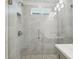 Modern shower with gray tile, glass enclosure, chrome fixtures, and a window for natural light at 2909 W Spruce St, Tampa, FL 33607
