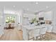 Open kitchen with white cabinets, quartz countertops, stainless steel appliances, and island with bar seating at 2911 W Spruce St, Tampa, FL 33607