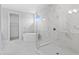Bright bathroom with marble-look tile featuring shower, free standing tub, and view to closet at 4017 W Fig St, Tampa, FL 33609