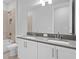 Modern bathroom featuring dual sinks, white cabinets, quartz countertops, and tiled shower at 4017 W Fig St, Tampa, FL 33609