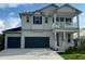 Two-story home featuring a light gray exterior, balcony, and a two-car garage at 4017 W Fig St, Tampa, FL 33609
