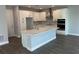 Modern kitchen featuring white cabinets, island with waterfall countertop, and stainless steel appliances at 4017 W Fig St, Tampa, FL 33609