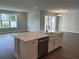 Kitchen island featuring a farm sink, dishwasher, and quartz countertops at 4017 W Fig St, Tampa, FL 33609