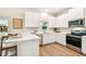 Bright kitchen boasts white cabinetry, stainless appliances, quartz countertops, and breakfast bar at 7615 S Swoope St, Tampa, FL 33616