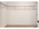 Empty walk-in closet with wire shelving and neutral carpet flooring at 7615 S Swoope St, Tampa, FL 33616
