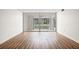 Open living room with wood-look floors and sliding glass doors at 19029 Us Highway 19 N # 4-5, Clearwater, FL 33764