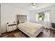 Bright bedroom with a queen bed, wood-look floors, and a window with curtains at 11116 Hoffner Edge Dr, Riverview, FL 33579