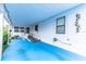 Mobile home with covered porch, ramp access, and blue concrete flooring at 7131 El Dewitt St, Zephyrhills, FL 33541