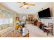 Bright living room featuring a large TV, comfy seating, and a ceiling fan at 7131 El Dewitt St, Zephyrhills, FL 33541