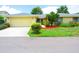 House exterior featuring a yellow house with attached garage and landscaping at 1306 Idlewood Dr # 53, Sun City Center, FL 33573